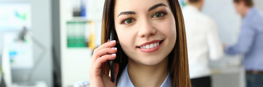 Young woman talking by phone in office. Remote customer service acceptance of orders concept