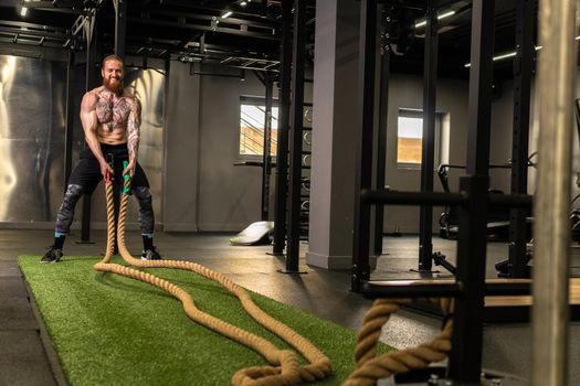 Rope man grass warehouse green fitness training gym exercising exercise, for athlete one from male from healthy moving, sport muscle. Standing ground holding, lifestyles