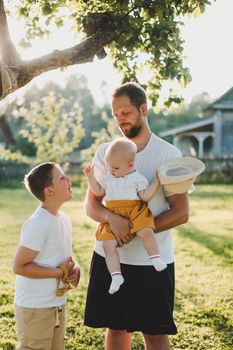 Happy father playing with his children outside in the park.