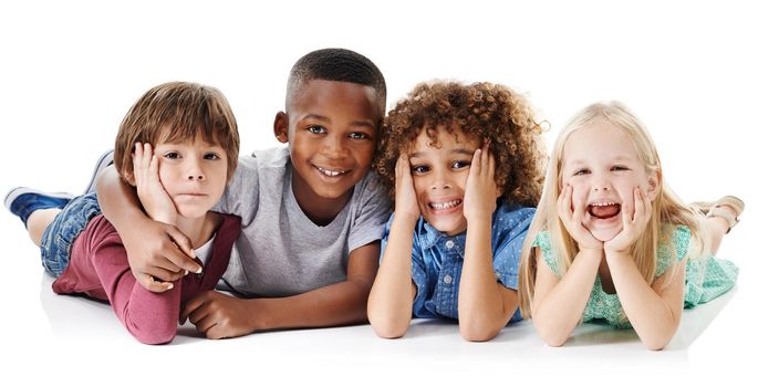 Studio shot of a group of young friends lying on the floor together against a white background.