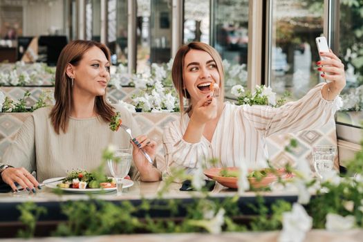 Two Women Making Selfie While Having Lunch Meeting, Female Friends Eating Salad in Restaurant