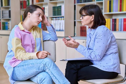 Psychologist, teacher, behavior, high school counselor counseling teenage student in library, office. Psychological help, social work, mental health, adolescence, youth psychotherapy psychology concept