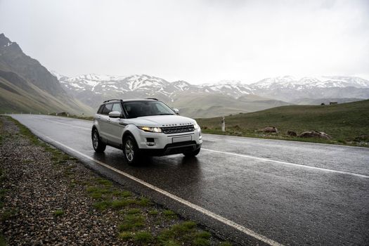 Range Rover Evoque car on the background of the mountains of the North Caucasus in Russia. Cloudy day on June 5, 2022.