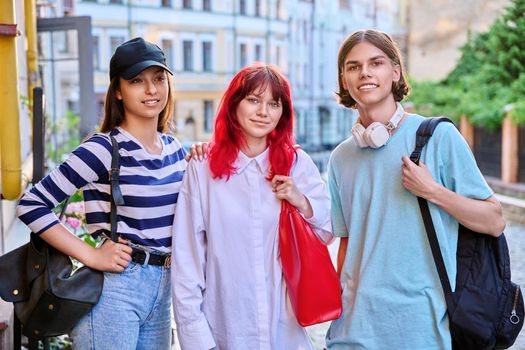 Happy smiling teenage friends, looking at camera outdoor, on city street. Friendship, community, youth, lifestyle, leisure fun concept