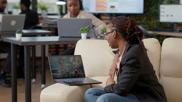 Female worker attending business meeting on videocall, using remote internet communication to talk to colleagues. Young woman chatting on online video teleconference, telecommunication.