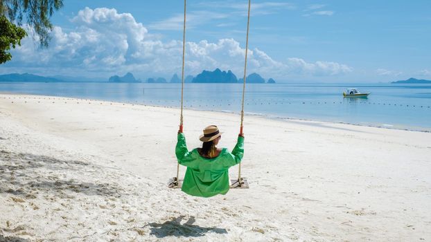 woman on the beach of the tropical Island Naka Island near Phuket Thailand, the woman at a swing on the beach. Naka Island Phuket Thailand