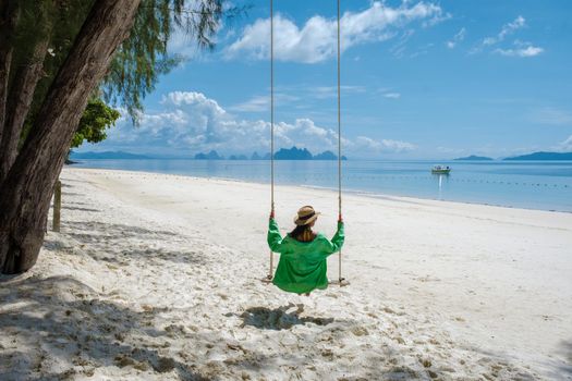 woman on the beach of the tropical Island Naka Island near Phuket Thailand, the woman at a swing on the beach. Naka Island Phuket Thailand