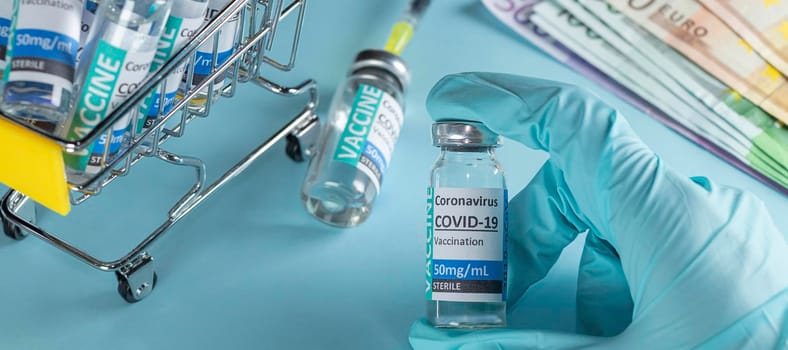 banner with Doctor, nurse, scientist, researcher hand in blue gloves holding coronavirus, covid-19 vaccine disease preparing for human clinical trials. Vaccine and euro. Soft focus