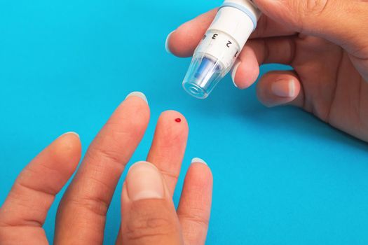 The lancet device pierces the finger close up