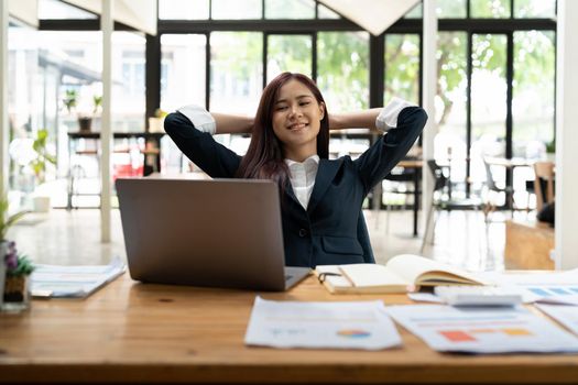 Young asian business woman having break and resting after solving task at modern office