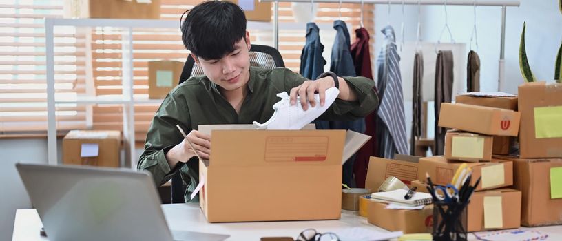 Young start up small business entrepreneur preparing parcel boxes for delivery.