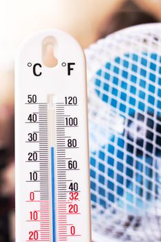 Small fan and room mercury thermometer close up