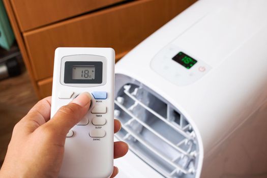 Air conditioner remote control in hand close up