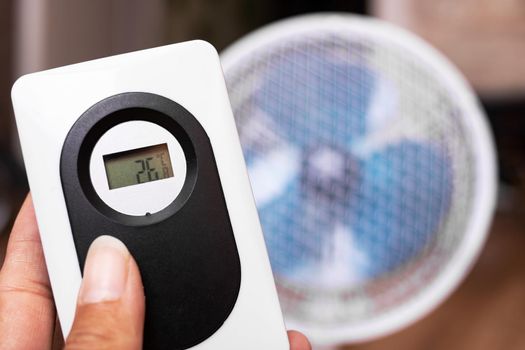 Small fan and room electronic thermometer close up