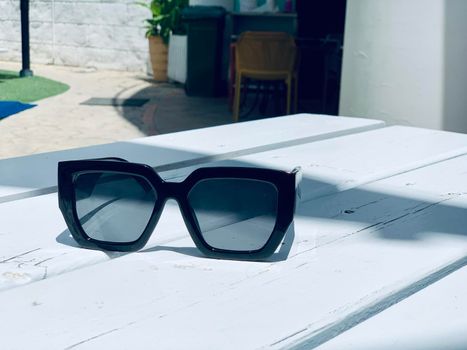 fashion sunglasses on wooden table. Vintage color style