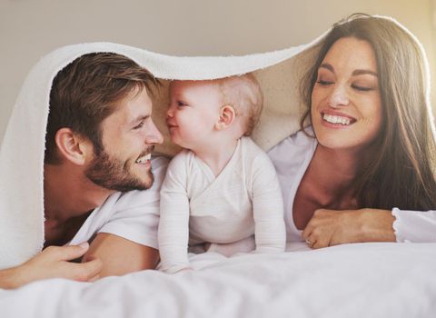 Cropped shot of a young couple and their baby daughter in the bedroom.