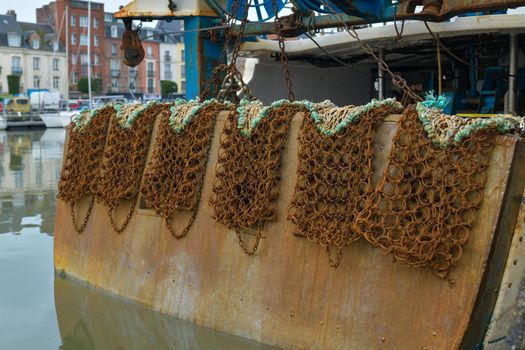 Rusty metal nets for catching scallops hang on a boat