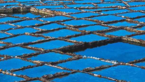 Rows of natural salt pans cut into the rock on the coast