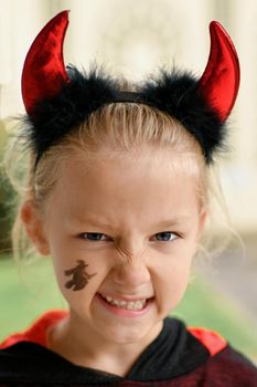 Scary girl dressed as a devil with horns