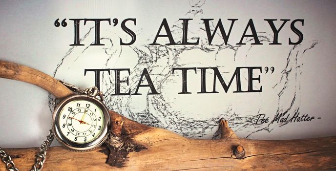 It´s always time for tea - silver pocket watch with chain on a tree branch quoting the Mad Hatter from Alice in Wonderland