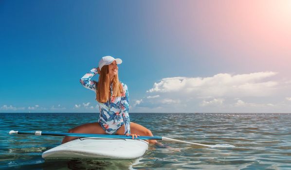 SUP Stand up paddle board. Young woman sailing on beautiful calm sea with crystal clear water. The concept of an summer holidays vacation travel, relax, active and healthy life in harmony with nature