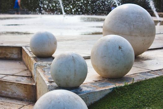 Giant white marble spheres on a modern design fountain in a public park