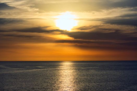 Stunning sunset in a dramatic sky above a serene, calm ocean