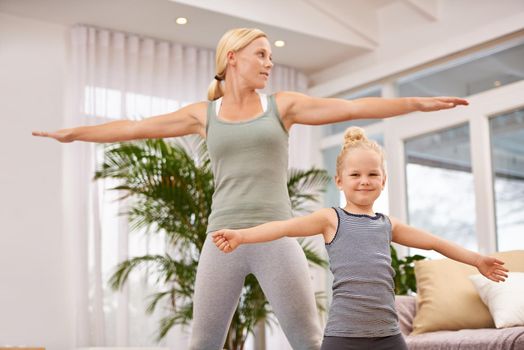 Full length shot of a mother and daughter doing yoga together.