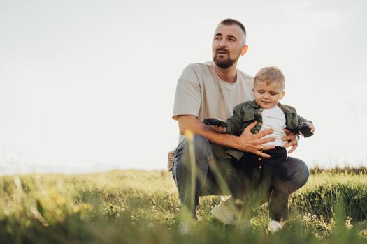 Father Holding His Little Son While Standing in Field, Portrait of Dad and Toddler Outdoors