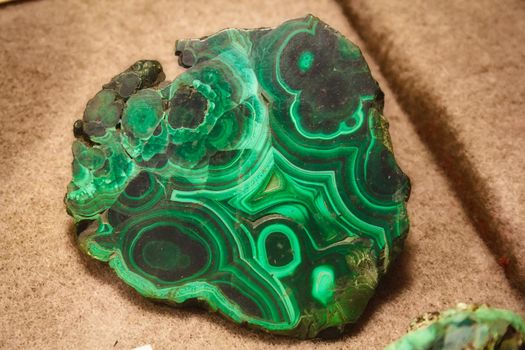 Close-up of polished malachite gemstone - green with wavy patterns used in jewelry