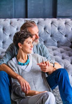 an aged couple sitting near the sofa thinking about something