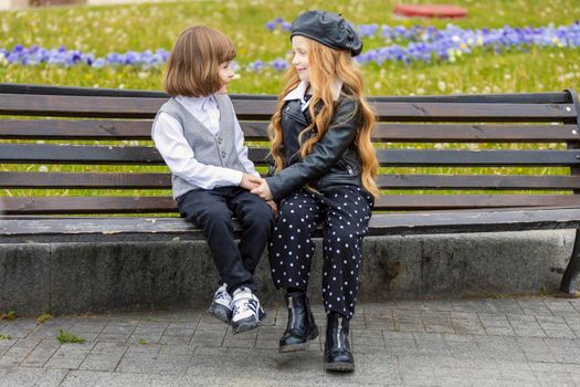 children sit on a bench in the city and talk