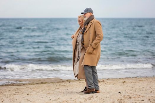 aged couple walking along the seashore