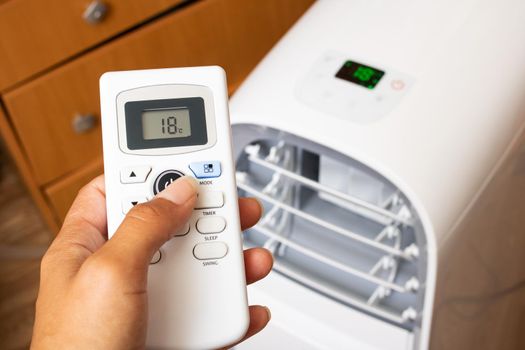 Air conditioner remote control in hand close up
