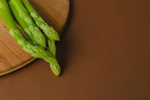 branches of fresh green asparagus on a wooden background, top view