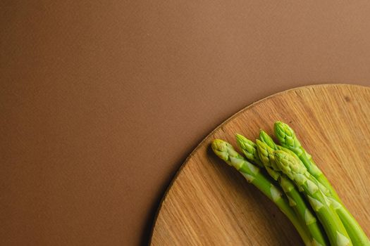 branches of fresh green asparagus on a wooden background, top view