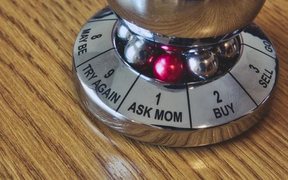 Metal decision maker with 'Ask Mom' selected from the wheel of options