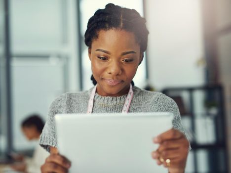 Shot of a fashion designer looking at something on her tablet.