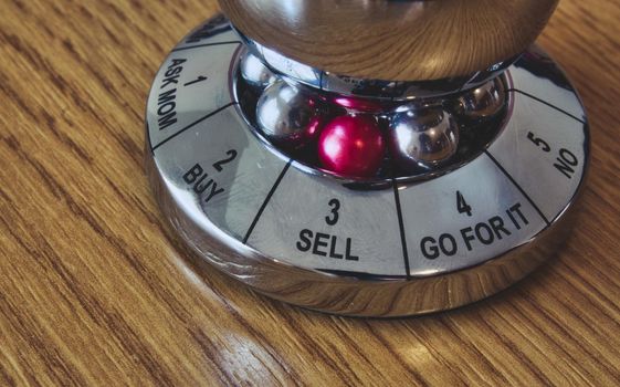 Metal decision maker with 'Sell' selected from the wheel of options