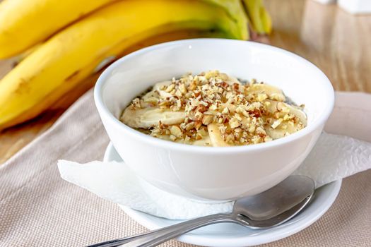 Dessert bowl of tasty chia seed pudding with banana on white background.