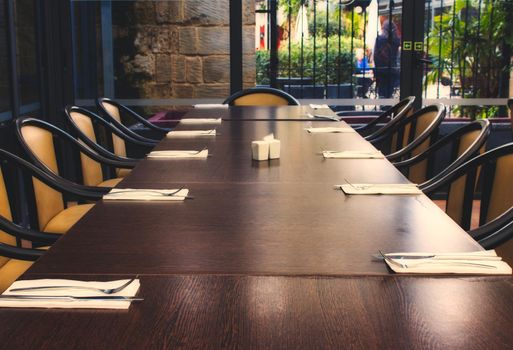 Long dining table with chairs in a restaurant