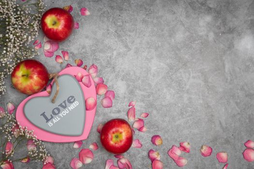 valentine's day gift in a heart-shaped box, mother's day, apples on the table and rose petals. High quality photo