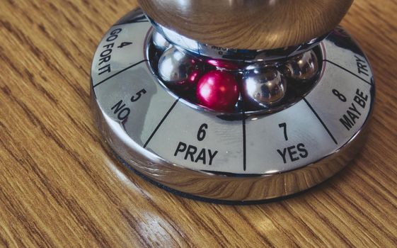 Metal decision maker with 'Pray' selected from the wheel of options