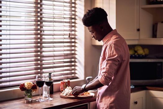 Cropped shot of handsome romantic young man preparing a meal on Valentines day at home.