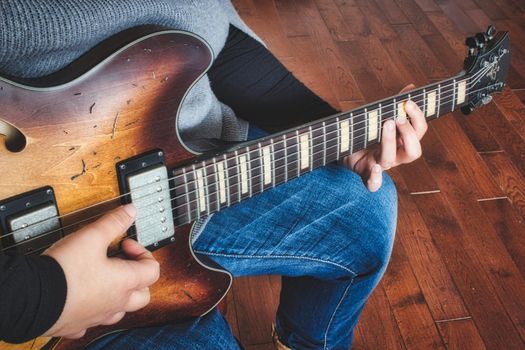 A woman playing an electric semi-hollow guitar