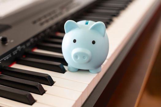 music and saving concept with piano and piggy bank.