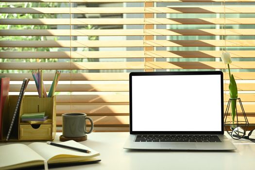 Mock up laptop computer, coffee cup and stationery on white office. Home office concept.