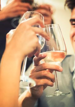 Group of friends toasting together with white wine.