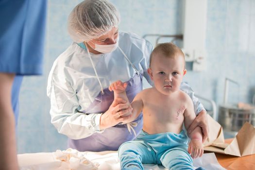 A little boy nurse treats a burn. A child in the hospital is injured. The doctor treats the baby. Little hospital patient.