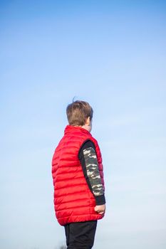 A child stands on top of a cliff and watches what is happening below. panoramic view from the top of a rocky mountain. Russia, Rostov region, skelevataya skala, the 7th wonder of the Don world. Landscape